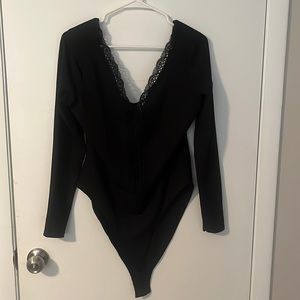 Black, stretchy material, with a lacy neck details.